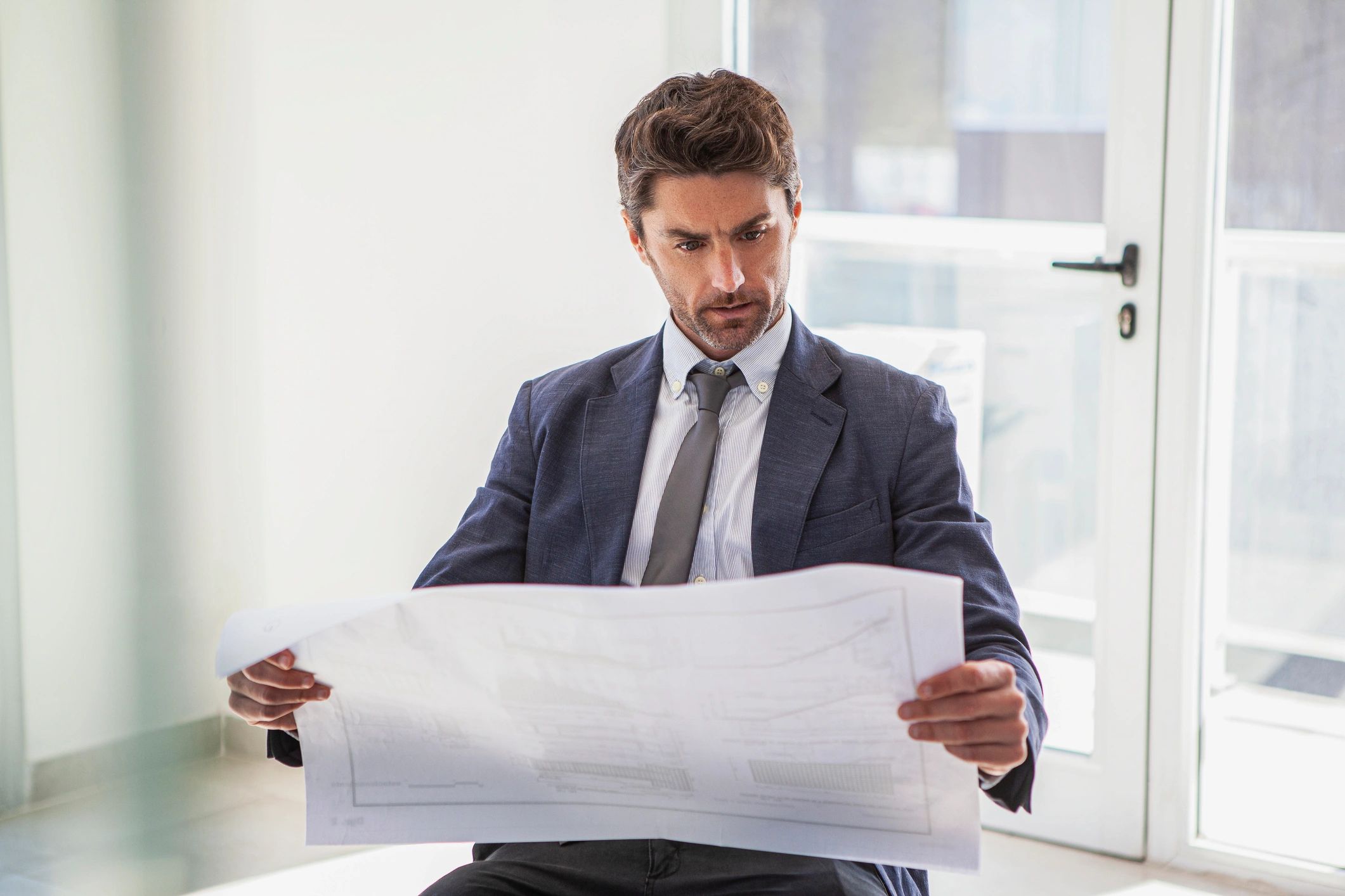 Consultant reviewing building plans in an office